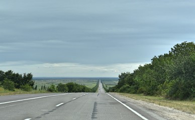 The road along the trees against the sky