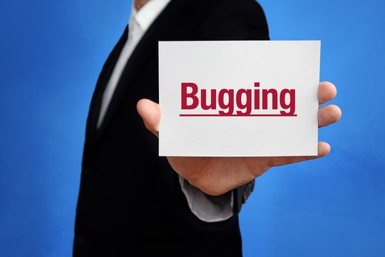 Bugging. Lawyer in a suit holds card at the camera. The term Bugging is in the sign. Concept for law, justice, judgement