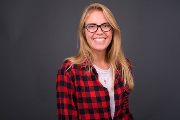 Portrait of happy young blond hipster woman with eyeglasses smiling