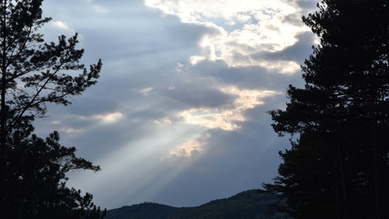 Fototapeta na wymiar Sonnenstrahlen durch graue Wolken, Licht, Hintergrund