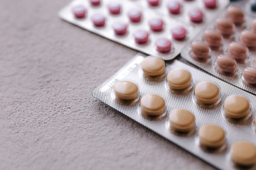 blisters of tablets of different colors - red, pink, green, blue pills and capsules