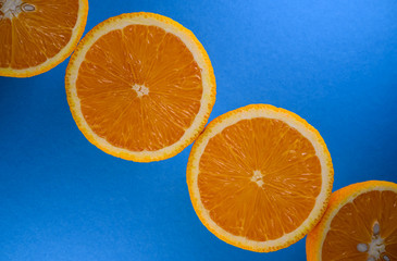 Fresh organic oranges isolated on blue background. Orange halves over blue background. Food...
