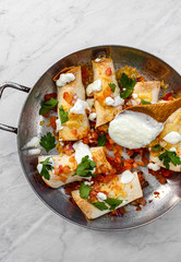 Mexican enchiladas topped with cheese, yoghurt sauce and coriander garnish. Vegetarian enchiladas made with lentils and red peppers. Mexican fast food. 