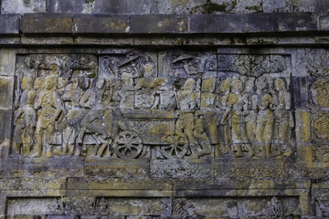 Beautiful reliefs covering Buddhist temple Candi Borobudur showing common live (samsara) to human enlightenment (nirvana). Borobudur temple located at Magelang, Central Java, Indonesia