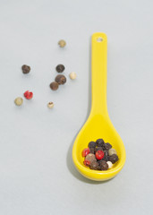 Yellow spoon whit pepper