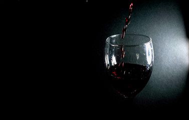 Fototapeta na wymiar Pour red wine into a glass