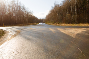 The asphalt road branches off in three directions. The intersection of three roads, wet after the...