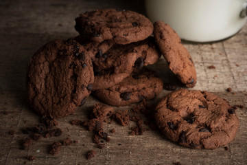 Close up the stack of chocolate cookies and a glass of milk