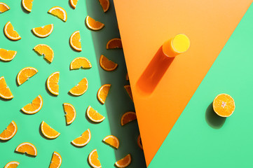 Orange juice glass and orange slices on duotone background. Summer drink