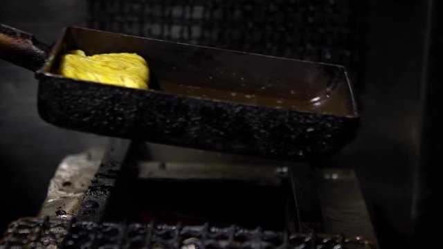 Slow Motion of tamagoyaki omelettes in metal pans at a street food market in downtown Tokyo. Popular Japanese street food in the izakaya restaurant.-Dan