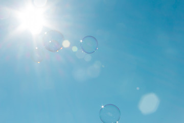 Soap bubbles floating in the air bathed by intense sunlight