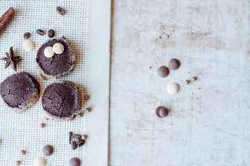 Tasty homemade cookies with spices:vanilla pod, cinnamon, cloves,crisps,coffee beans,drops of white and black chocolate lying on a vintage canvas background.Copy space.Texture. Concept of cosy morning