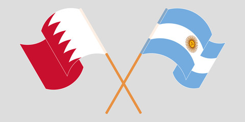 Crossed and waving flags of Bahrain and Argentina