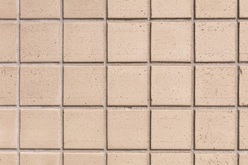 Beige square tile. Close-up wall