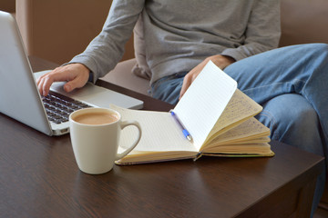 Online and remote work or home distance education concept. Close up of a young female freelancer working on a laptop from a home office