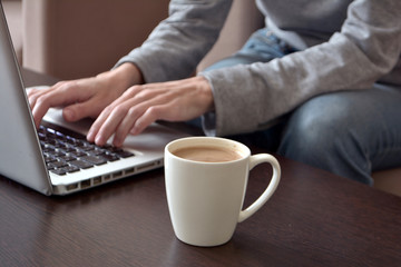 Online work or home education concept. Close up of a young female freelancer working on a laptop from a home office