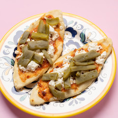 Mexican tlacoyos with nopal cactus and cheese on pink background
