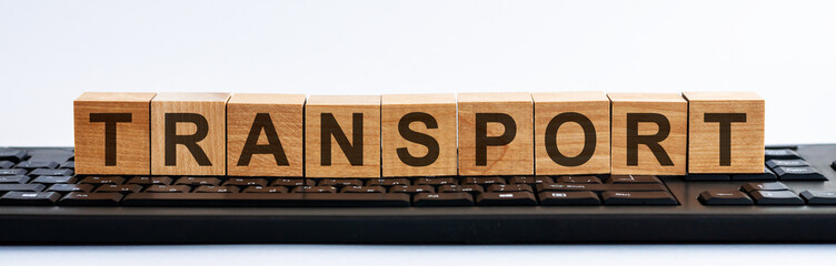 TRANSPORT-text on wooden cubes located on the keyboard, white background. The business model and financial success.