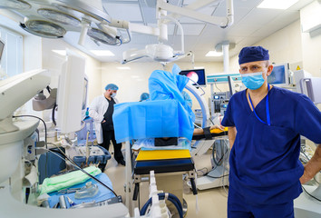 Medical worker getting ready for surgical operation in bright modern surgery room. Operating theatre. Modern equipment in clinic. Emergency room.