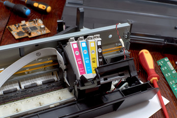 The printer is disassembled. Repair of the printer. Color ink cartridges for an inkjet printer. An...