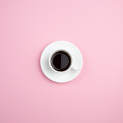 Cup of coffee on pastel pink minimal background