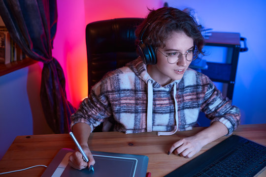 Digital desinger using graphic tablet and stylus. Freelancer desinger working from home