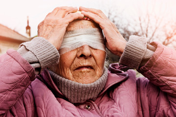 Old grandmother with a blindfold. Conceptual photo of an old woman blindfolded. Grandmother in fear...