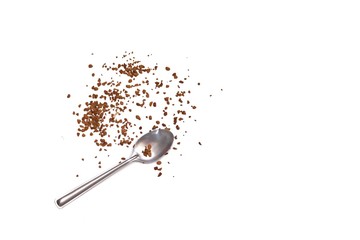 In selective focus a pile of instant coffee powder with a silver coffee spoon on white isolated background 