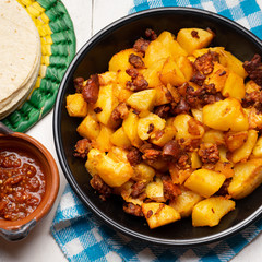 Mexican potatoes with chorizo on white background