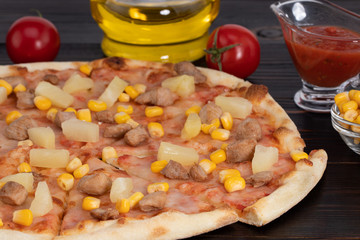 Pizza with chicken, pineapple and corn on dark background