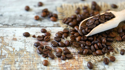 Selective focus. Macro. Grains of coffee in a wooden spatula.
