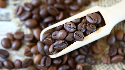 Selective focus. Macro. Grains of coffee in a wooden spatula.