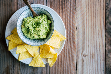 Guacamole fait maison avec des tortillas chips de maïs - Préparation traditionnel mexicaine épicée