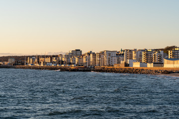 Fototapeta premium Helsingborg coastline as seen from pier at sunset on a windy spring day in Scania, Sweden.