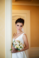 beautiful bride stands at the door of the hotel