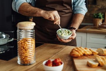 Close-up of a cook preparing healthy meal in the kitchen.