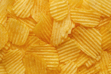 Golden potato chips background. Flat lay, top view, copy space for text