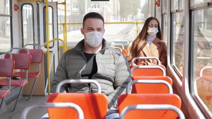 Young man and woman with protective mask traveling in the public transport by bus - Powered by Adobe