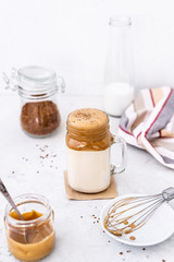 Trendy dalgona coffee in glass on white background.Korean drink latte espresso with foam of instant coffee. New popular food and drink trend. Selective focus