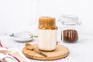 Trendy dalgona coffee in glass on white background.Korean drink latte espresso with foam of instant...