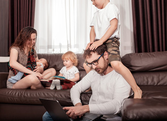 Father works at home. Full family stay home. Father freelancer try to work at home with children.