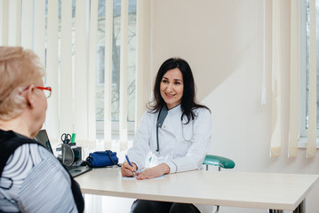 Fototapeta premium A couple of elderly people at a personal doctor's appointment at a medical center. Medicine and healthcare