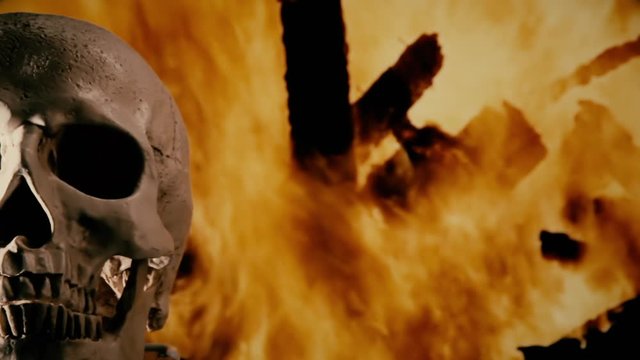 A scary human skull, rotating on its axis on the left side of the screen, over a fire pyre at night (burning wood).
