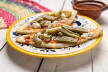 Mexican tlacoyos with nopal cactus and cheese on white background