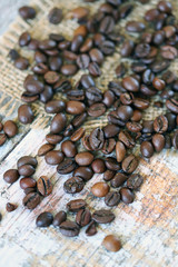 Selective focus. Macro. Coffee beans are scattered on a wooden surface.