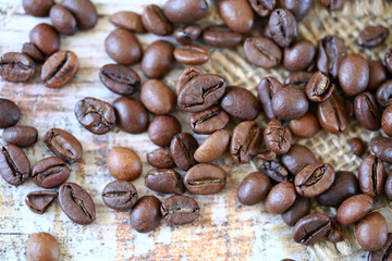 Selective focus. Macro. Coffee beans are scattered on a wooden surface.