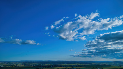 Plakat Blue sky and multiple clouds background showing a horizon