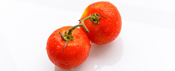 2 bright and juicy red tomatoes on a branch, horizontal banner, background for the site, there is room for text