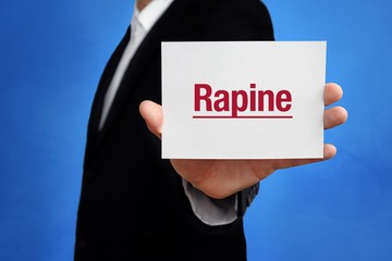 Rapine. Lawyer in a suit holds card at the camera. The term Rapine is in the sign. Concept for law,...