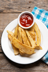 French fries with ketchup sauce on wooden background